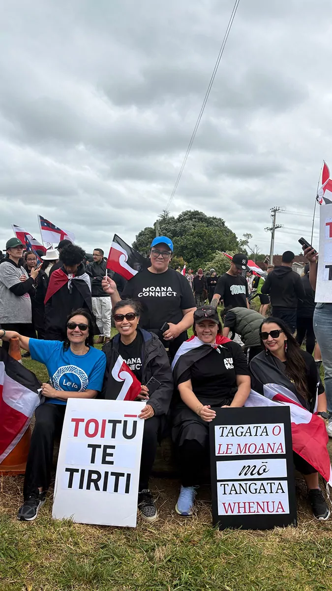 Le Va and friends at Ihumātao smiling with signs and flags