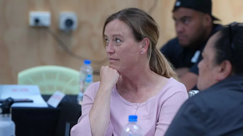 Woman in pink shirt listening with hand on chin