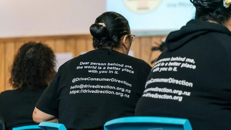 Back view of women in black t-shirts with inspiring message on them